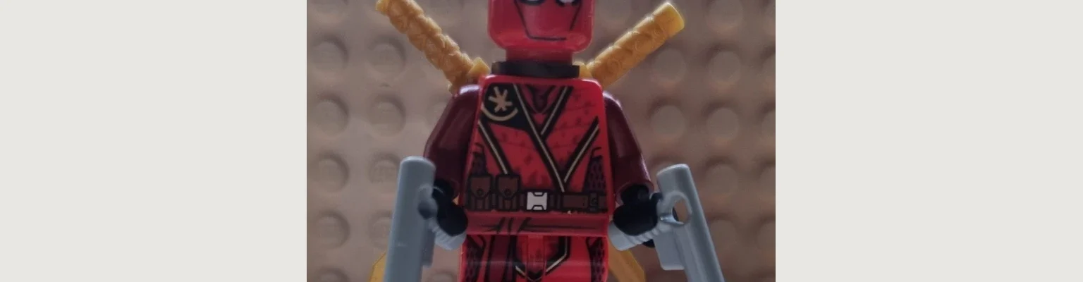 Customowa minifigurka inspirowana Deadpoolem, sfotografowana jako własna konstrukcja z klocków.