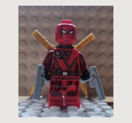 Customowa minifigurka inspirowana Deadpoolem, sfotografowana jako własna konstrukcja z klocków.