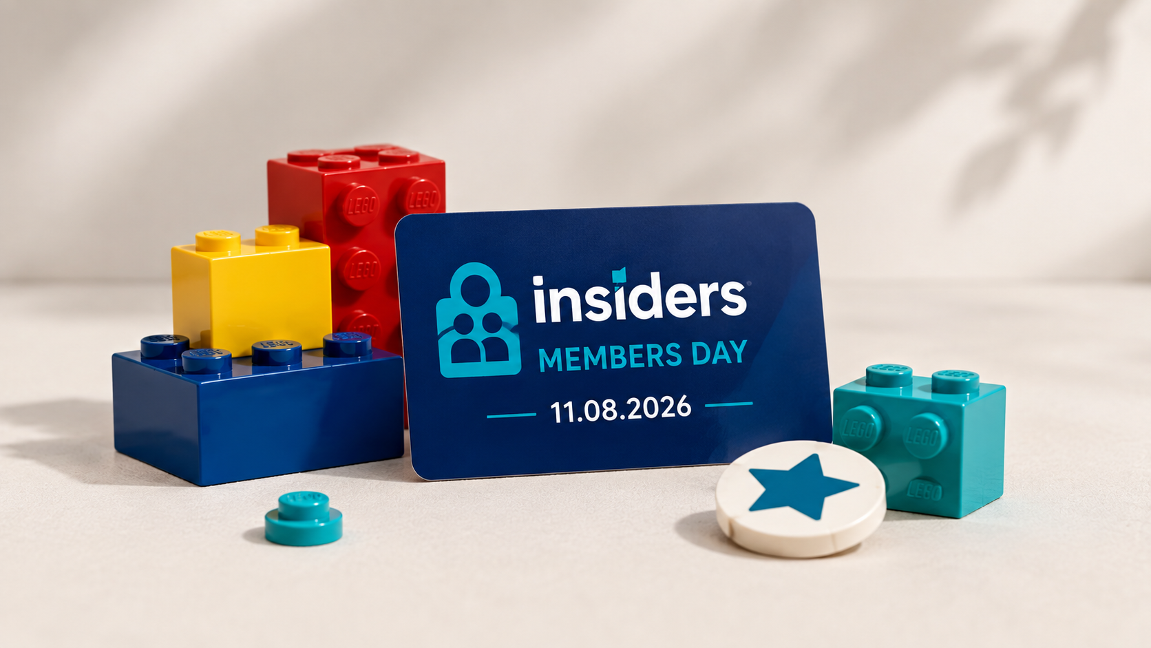 Karta z napisem LEGO Insiders Members Day i datą 11.08.2026 ustawiona wśród kolorowych klocków na jasnym tle.