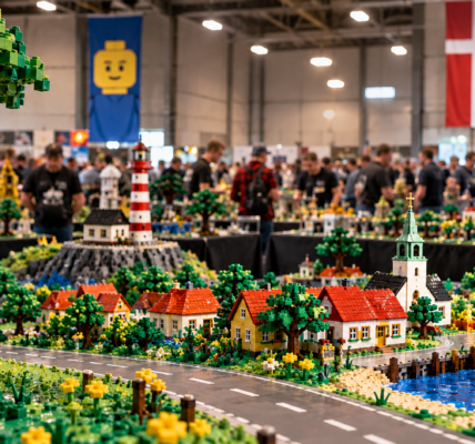 Fanowska wystawa LEGO w hali z rozbudowaną makietą duńskiego miasteczka, latarnią morską, portem i uczestnikami wydarzenia w tle.